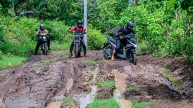 Kondisi jalan berlubang dipenuhi genangan air dan lumpur