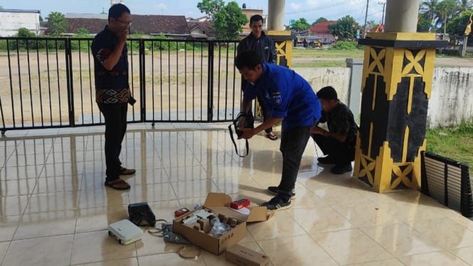 Petugas sedang memasang jaringan internet gratis