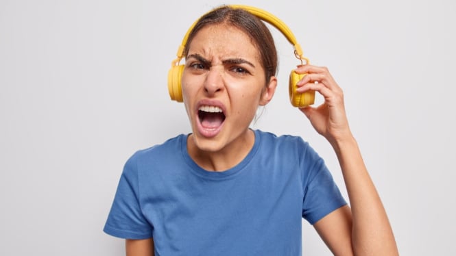 Seorang wanita yang frustasi mendengarkan kualitas musik bajakan