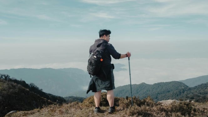 Ilustrasi seorang lelaki mendaki gunung
