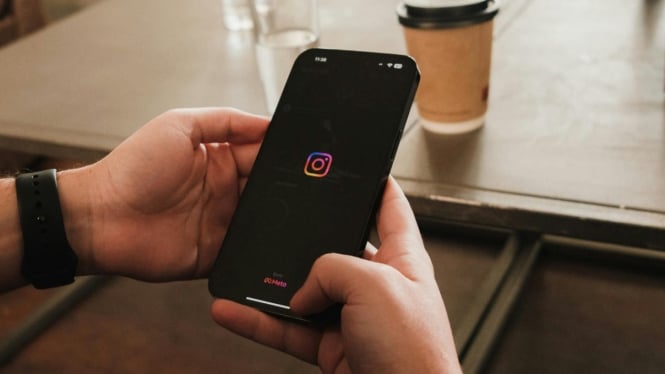 Ilustrasi seseorang sedang membuka aplikasi Instagram.