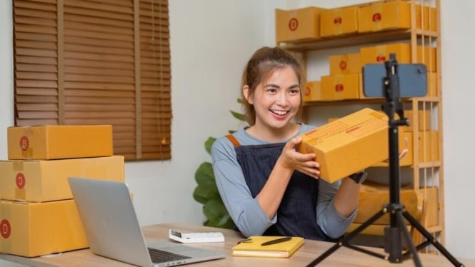 Wanita muda yang melakukan promosi dengan live streaming