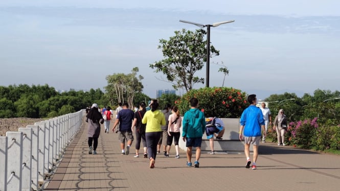 Berjalan kaki, sambil menikmati suasana di pagi hari.