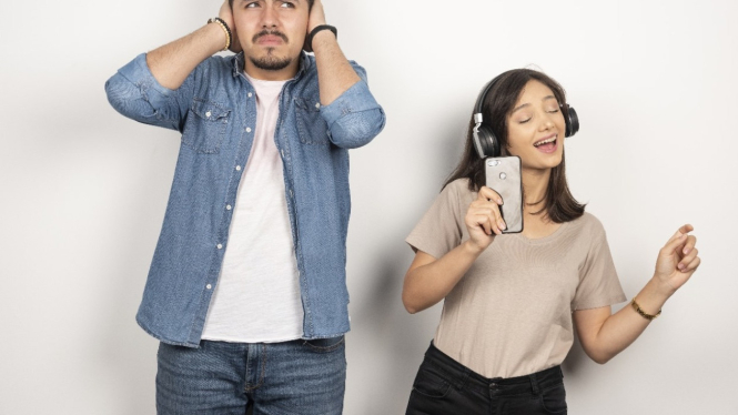Seorang pria terganggu dengan musik yang di dengarkan temannya