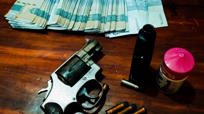 Ilustrasi pistol polisi dan uang tunai