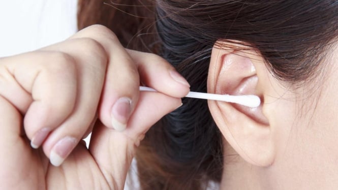 Ilustrasi seorang wanita membersihkan telinga menggunakan cotton bud