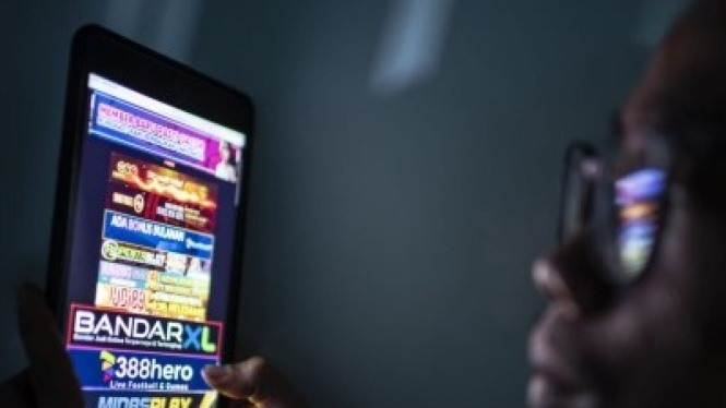 Ilustrasi seorang pria yang sedang bermain judi online