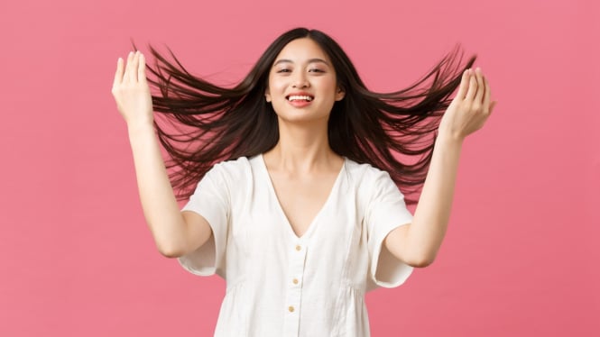 Perempuan dengan rambut sehat dan berkilau