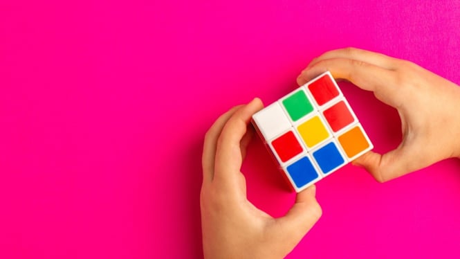Ilustrasi Seseorang Sedang Menyelesaikan Rubik