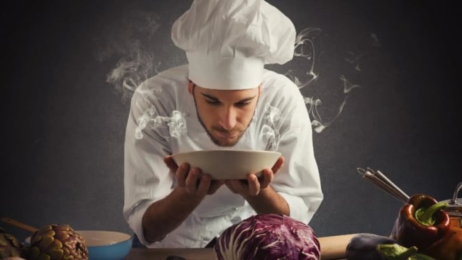 Seorang chef yang sedang mencium aroma masakan yang sedap