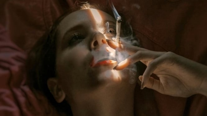 Ilustrasi seorang wanita sedang mengonsumsi rokok.