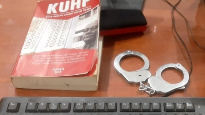 Ilustrasi KUHP dan borgol milik Polisi