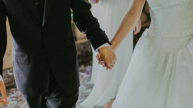 Pengantin baru yang sedang berpegangan tangan