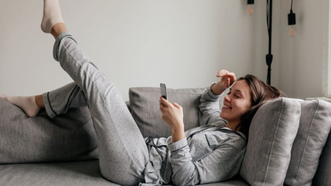 Seorang cewek sedang rebahan di sofa