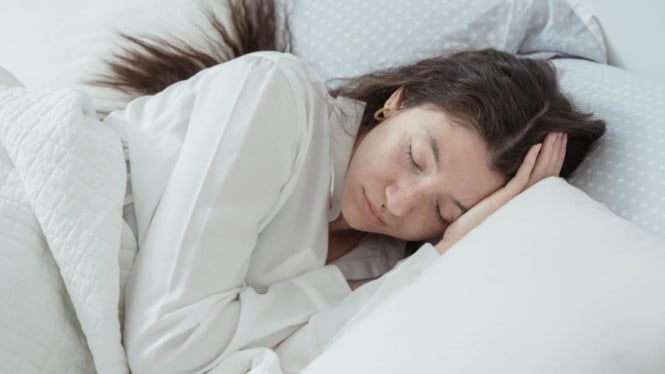 Ilustrasi seseorang tidur dengan rambut agak lembap.