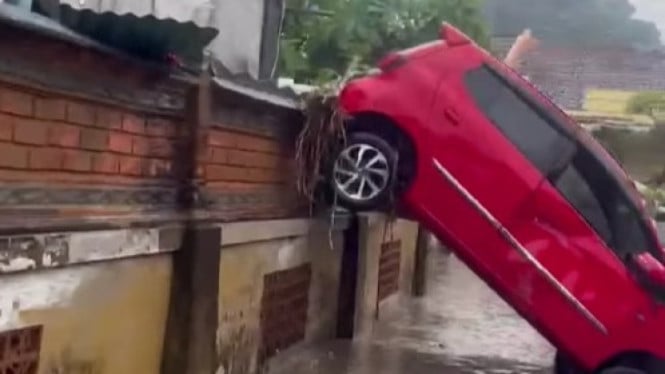 Mobil milik warga terguling akibat diterjang banjir
