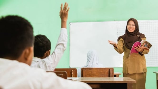 Seorang guru sedang mengajarkan pelajaran kepada murid.