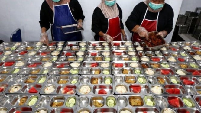 Petugas sedang menyiapkan makanan dari program MBG