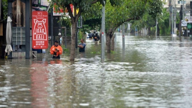 Driver ojek online, sedang menerobos banjir di bali