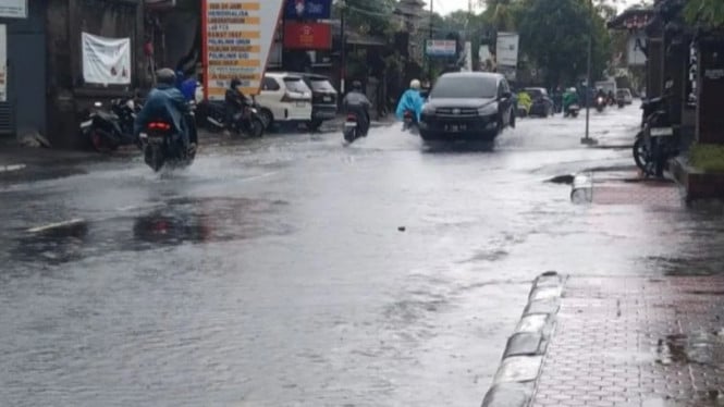Sejumlah kendaraan melintasi genangan banjir di Gianyar