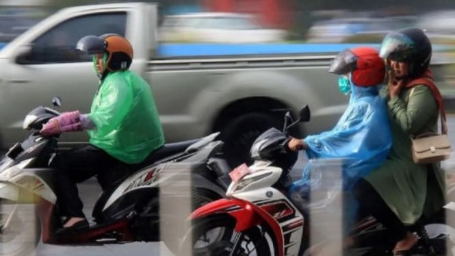 Pengendara motor melintas saat hujan mengguyur di jalan