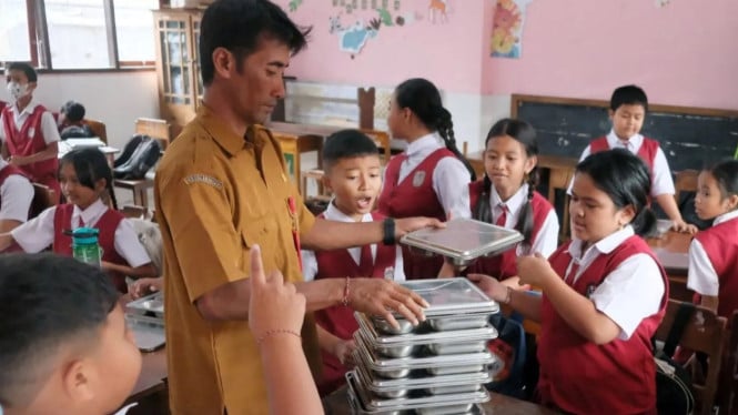 Guru sedang membagikan MBG kepada Murid-murid