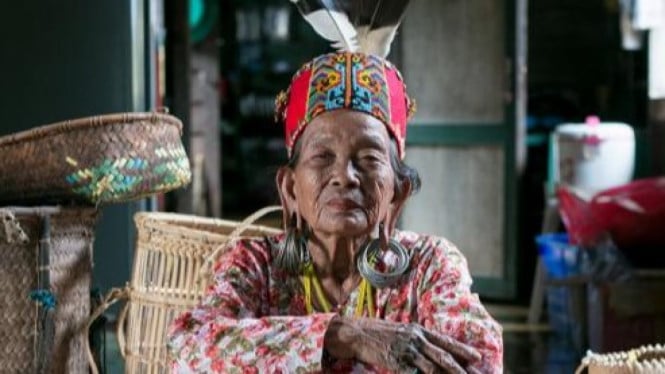 Wanita Dayak menggunakan Anting atau Telingaan Aruu