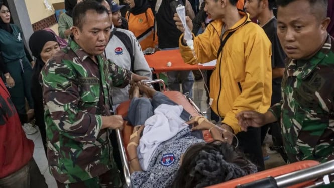 Anggota TNI bersama relawan mengevakuasi korban keracunan massal