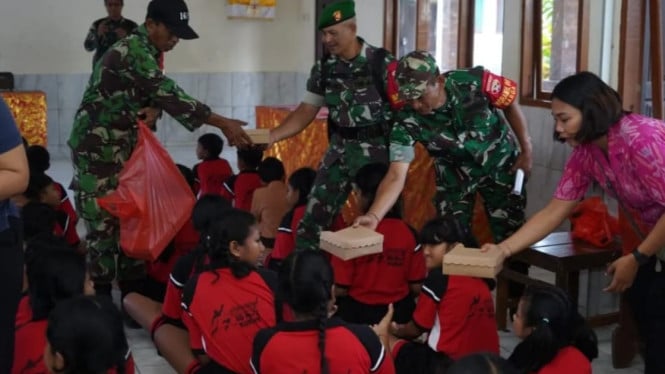 Anggota Kodam IX/Udayana membagikan MBG kepada siswa