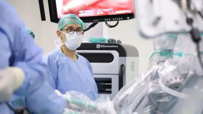 Seorang tenaga kesehatan mengoperasikan alat operasi