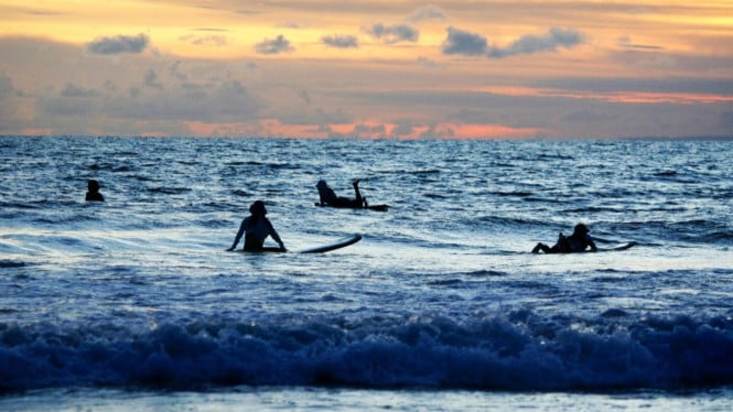 Wisatawan berselancar di Pantai Kuta, Badung