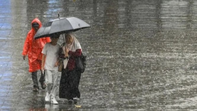 Terlihat beberapa masyarakat menggunakan payung dan jas hujan