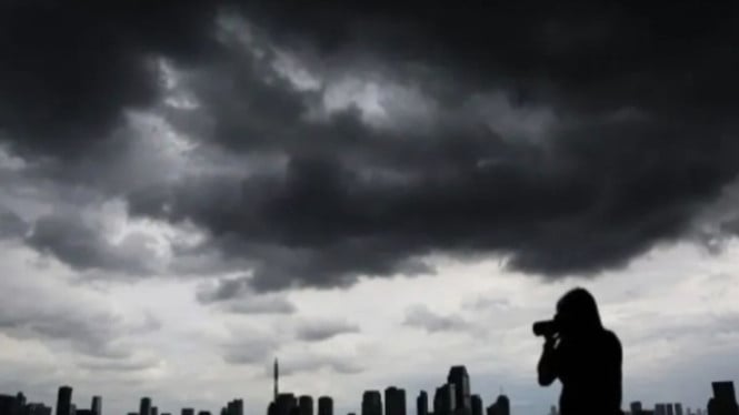Penampakan awan tebal yang menyelimuti gedung tinggi di Jakarta.