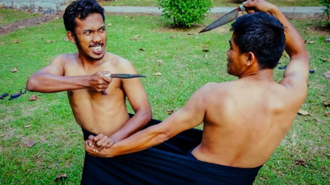 Dua orang pria bertarung dalam sarung