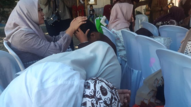 Anak - anak bersimpuh di kaki ibunya