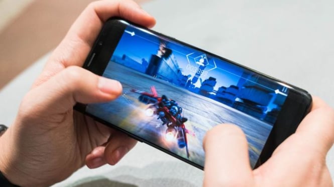 Seseorang bermain game di smartphone