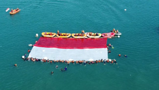 Bukan Bendera Jolly Roger One Piece, Relawan Kibarkan Merah Putih Raksasa di Laut Merak