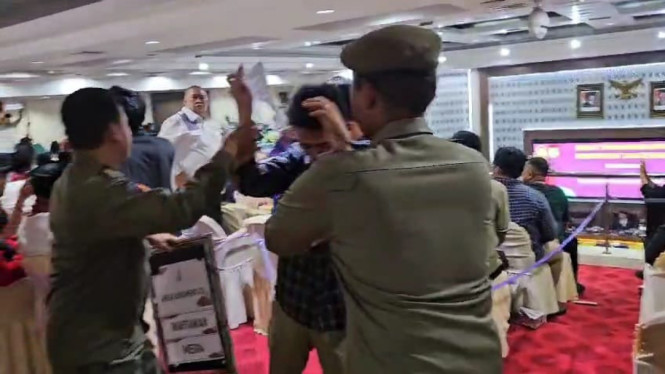 Seorang massa aksi saat diamankan petugas usai terobor rapat paripurna