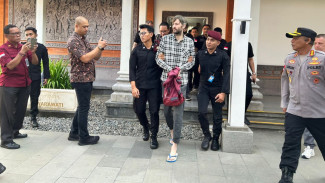 Bergaya Santai. WNA Buronan Interpol Diekstradisi dari Bali ke Rusia Hanya Pakai Sandal Jepit
