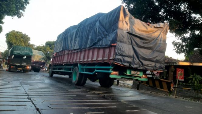 Truk besar melintasi jembatan darurat