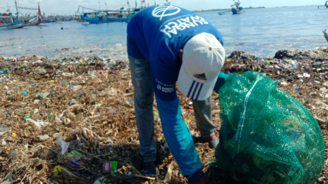 Relawan Sungai Watch memunguti sampah di area pantai Tratas