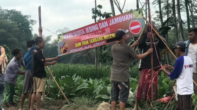Warga memasang banner penolakan tambang galian C di Jember