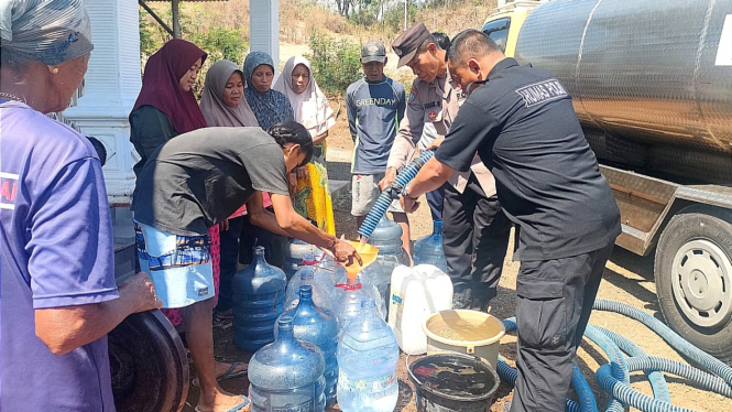 Warga antre mendapatkan bantuan air bersih.