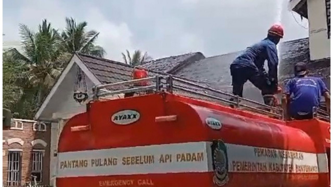 Petugas Dinas Pemadam kebakaran mengevakuasi titik atap terbakar