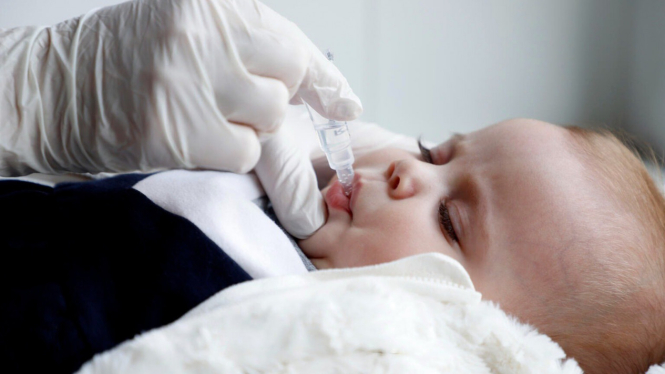 Bayi diberi imunisasi polio.