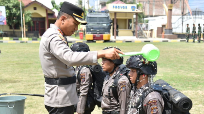 Kapolres Bireuen, AKBP Jatmiko, S.H., M.H menyiramkan air bunga