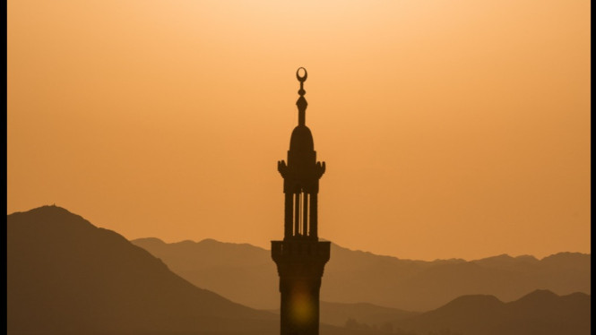 Menara masjid dengan pemandangan gunung dibelakangnya