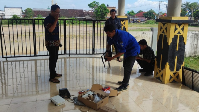 Petugas sedang memasang jaringan internet gratis