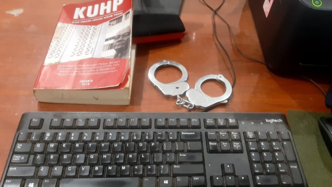 Ilustrasi borgol polisi dan buku KUHP