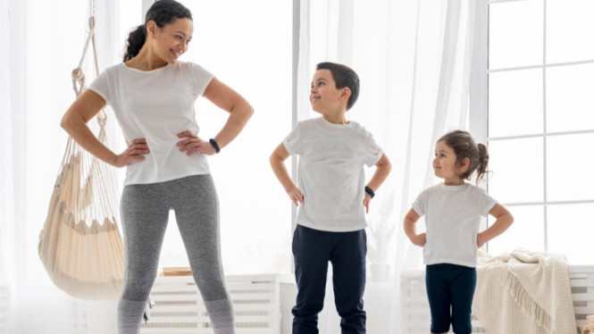 Ibu stretching ringan bersama anak di rumah.